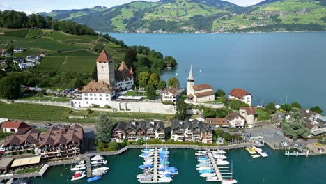 drohnen-orbit-aufnahme des hafens von spiez mit dem schloss und dem thun-see im kanton bern in der schweiz