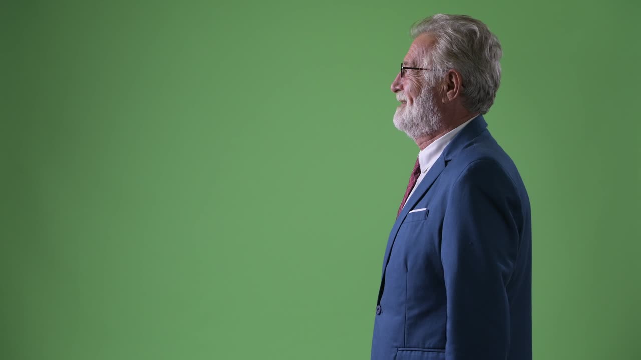 hombre de negocios barbudo y guapo contra un fondo verde.