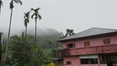 Una-Antigua-Casa-Roja,-Espeluznante-Y-Envuelta-En-Niebla,-Enclavada-En-Lo-Profundo-De-La-Exuberante-Y-Aislada-Selva-Tropical