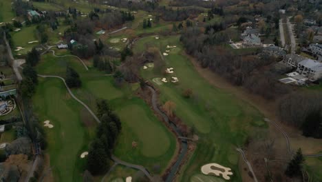 Toma-Aérea-De-Drones-Volando-Sobre-Un-Campo-De-Golf-Y-Revelando-El-Horizonte-De-Una-Ciudad-En-Toronto,-Ontario,-Canadá