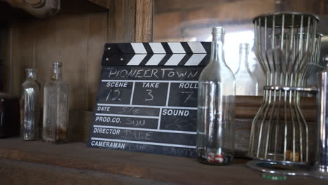 Clapperboard-An-Empty-Glass-Bottles-Display-Inside-The-Saloon-In-Pioneertown,-California