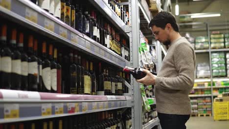 man choosing wine in grocery store