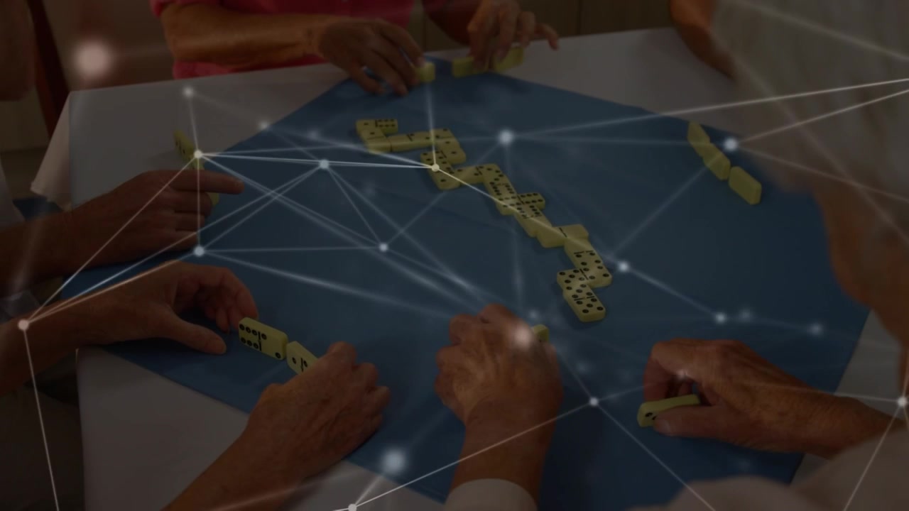 Group of Seniors Playing Dominoes Together at a Table