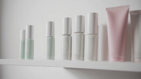 close-up of various pastel-colored cosmetic and toiletry products on a shelf