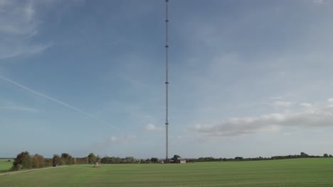 Raptor-Ratonero-Común-Volando-Sobre-El-Campo-En-Dinamarca-Con-Torre-De-Radio-Y-Televisión-En-El-Fondo---Vista-De-Drones