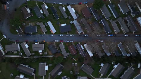 Top-down-view-of-a-curved-road-amidst-mobile-homes-and-vehicles-at-dusk