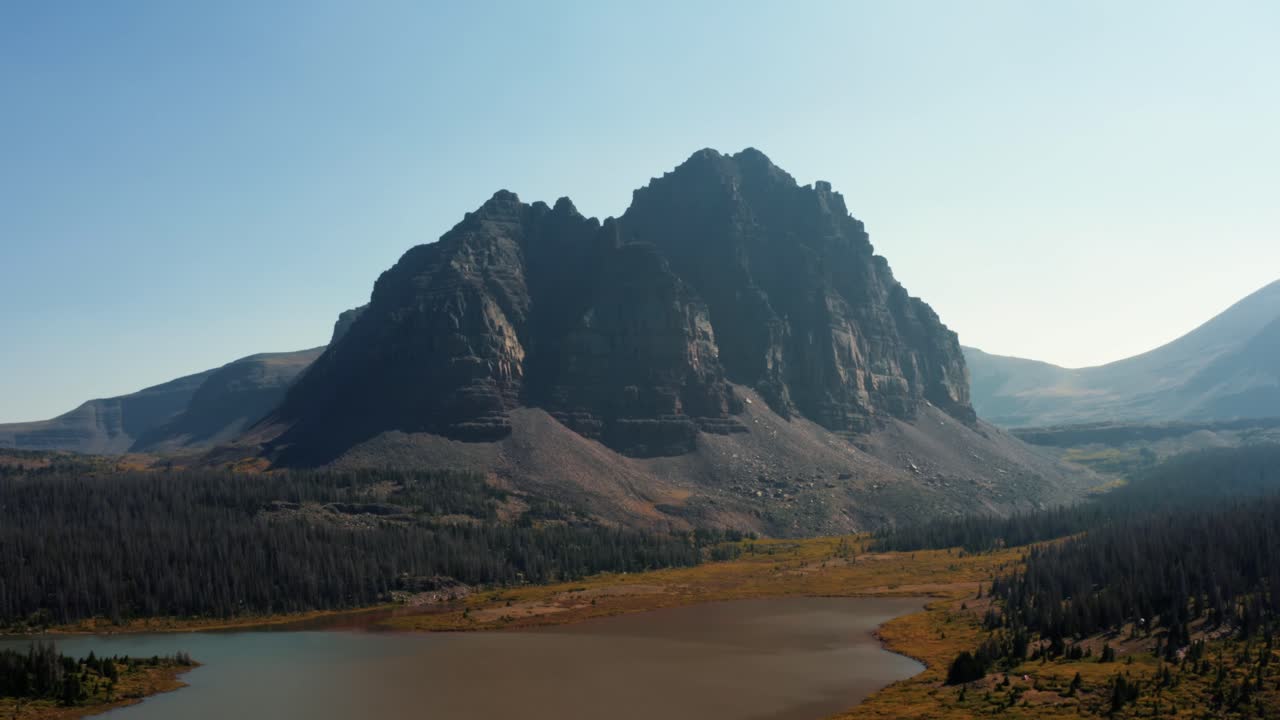 impresionante paisaje de drones aéreos naturaleza tiro ascendente de un gran prado con un pequeño arroyo con el hermoso lago del castillo rojo inferior y el pico detrás en el bosque nacional de uinta alto en utah