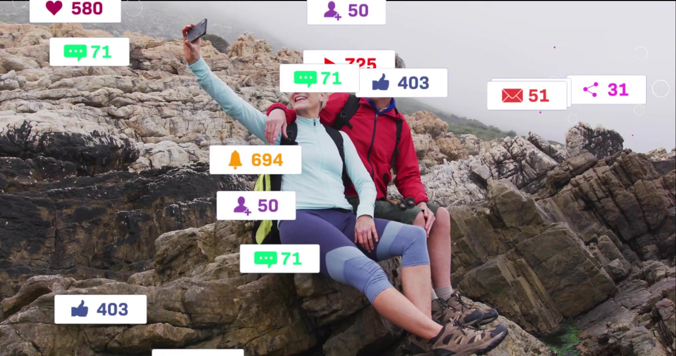 Seniorpar læner sig sammen og tager en kyst-selfie, hvilket udløser flydende notifikationer fra sociale medier.