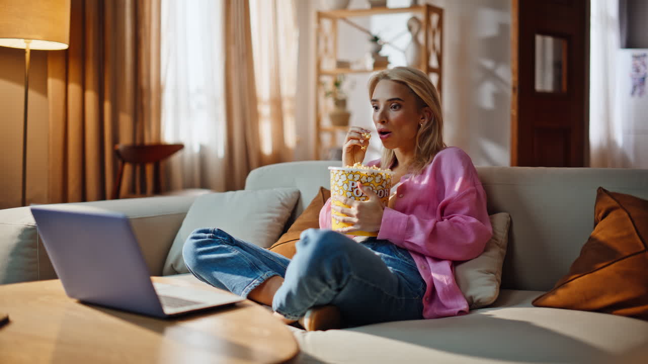 Girl scared horror movie light home couch. woman watching scary film