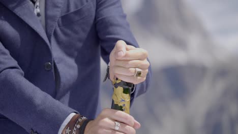 person wearing formal suit opening carefully champaign bottle