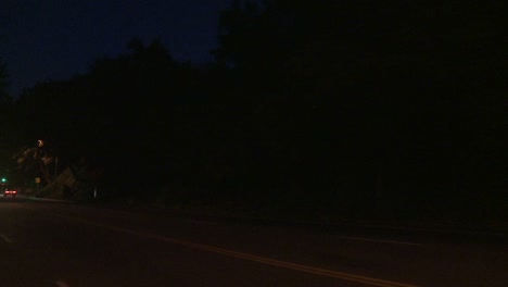 A-Car-Travels-Along-A-Street-At-Night-In-Los-Angeles-California-As-Seen-Through-The-Rear-Window-At-An-Angle-3