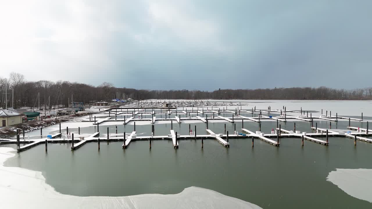 Aerial pushing in on a frozen winter dock at Presque Isle State Park.