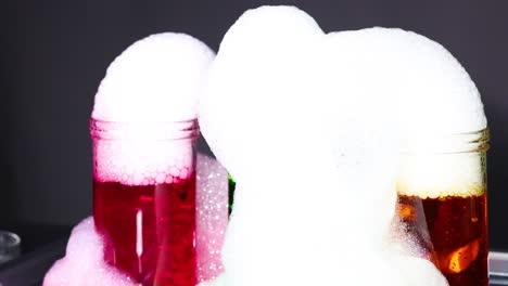 Vibrant dry ice bubbles overflow from jars, creating a mesmerizing science experiment with colorful liquids and dynamic foam