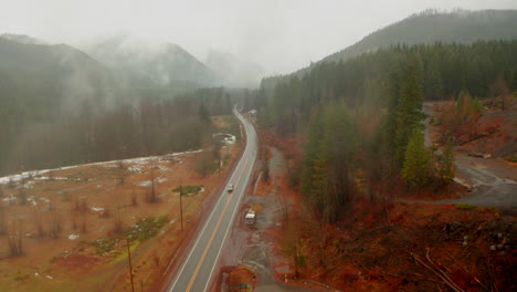 Descending-aerial-shot-of-road-into-small-mining-town-in-rural-Oregon-America