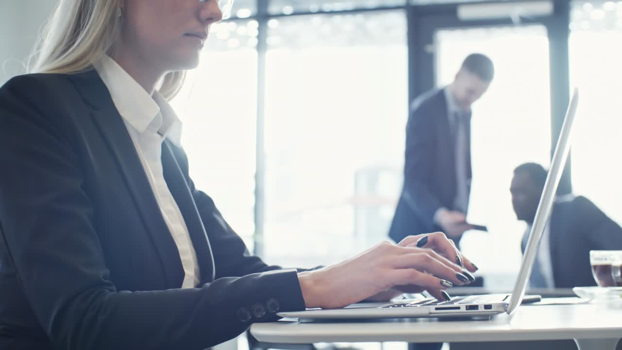 Frau tippt am Laptop im Coworking Space