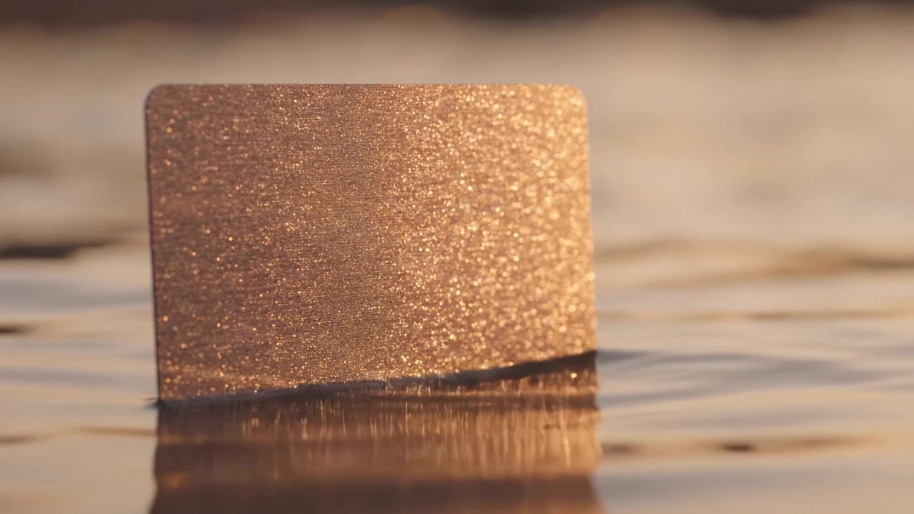 Une carte métallique chatoyante flotte sereinement sur l'eau, capturant la douce lueur du soleil, créant une harmonie visuelle envoûtante avec les reflets naturels.