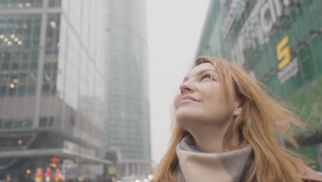 woman looking up at city buildings