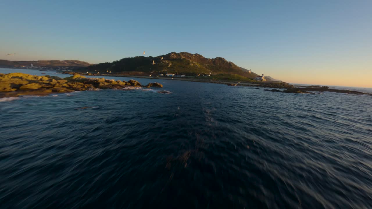 FPV drone flying along the Atlantic coast of Galicia at golden hour with waves and seagulls