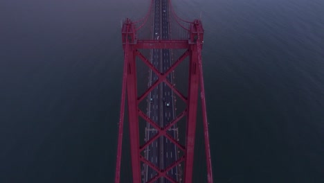 flying above red ponte 25 de abril portugal bridge with sunrise, aerial