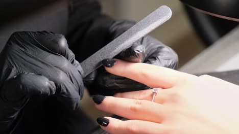 woman uses a nail file in a beauty shop