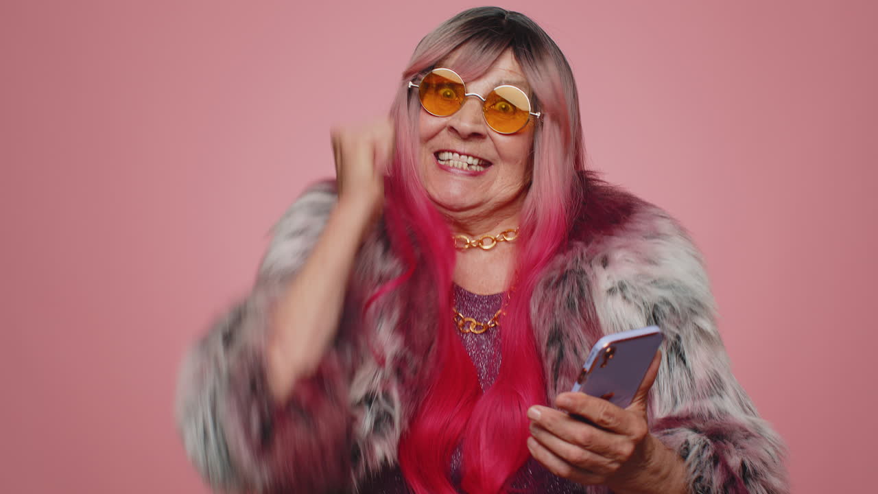 mujer feliz y emocionada usa el teléfono móvil y dice wow, sí, descubrí una gran noticia sobre una gran victoria haciendo un gesto de ganador