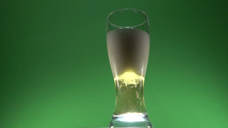 foam of beer slowly ascending on a glass of beer