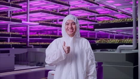 asian male scientist showing thumbs up gesture and smiling in vertical farm