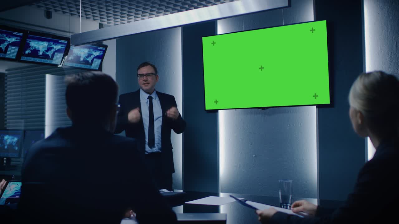 Chief Strategy Officer Showing Report to a Board of Directors and Business Partners, Using Green Mock-up Screen in the Monitoring Room.