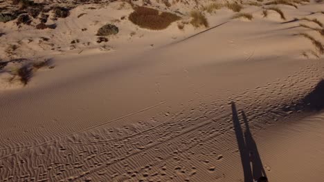 newlywed couple walking on sandy sea coast