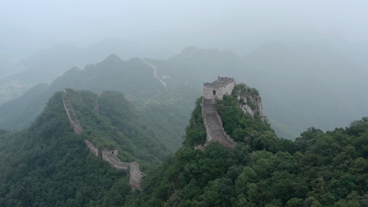 Great Wall of China stretching over mountain ridge on a foggy overcast day