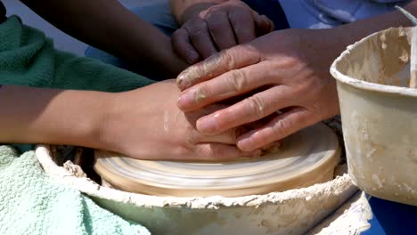 las manos del alfarero trabajan con arcilla en la rueda del alfarer