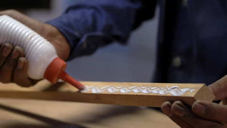 Closeup Shot Of Woodworker Installing Wood To Table Top With Glue, Furniture Making Factory