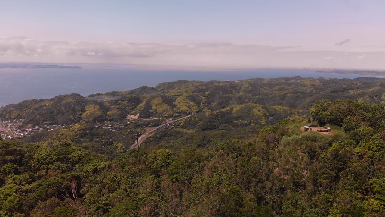 hombre parado en una plataforma de observación en la cumbre de una montaña - panorámica de tiro aéreo a la derecha