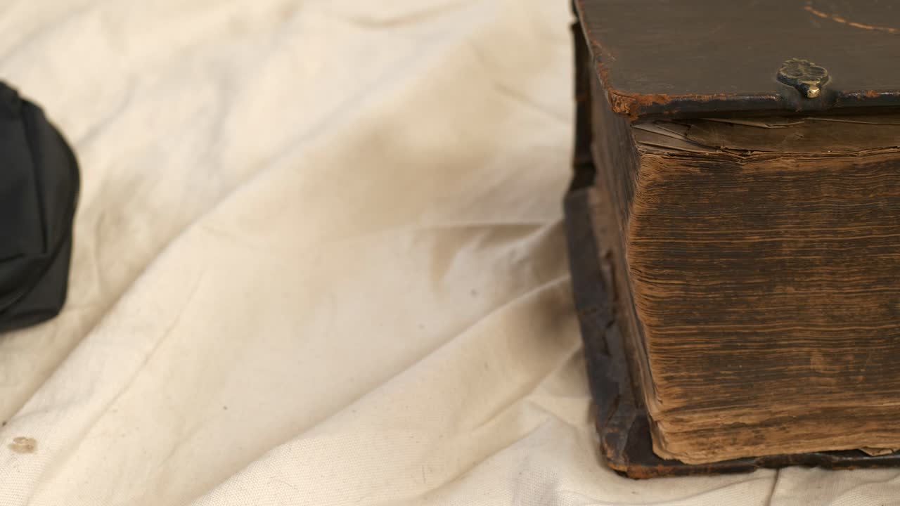 Primo piano della copertina di un libro vecchio e spesso con bordi usurati che viene chiuso.