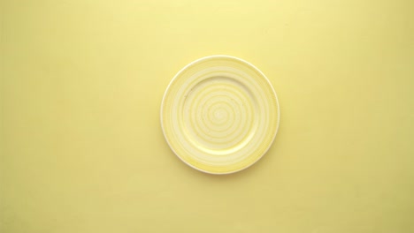 poniendo un plato vacío sobre un fondo amarillo