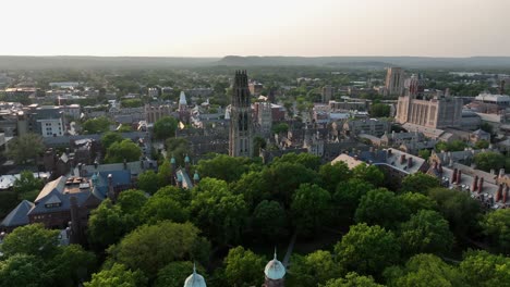 peaceful golden hour in american city with famous yale university and harkness tower. aerial forward wide shot