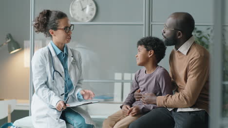 Female-Pediatrician-Talking-and-Giving-High-Five-to-African-American-Boy