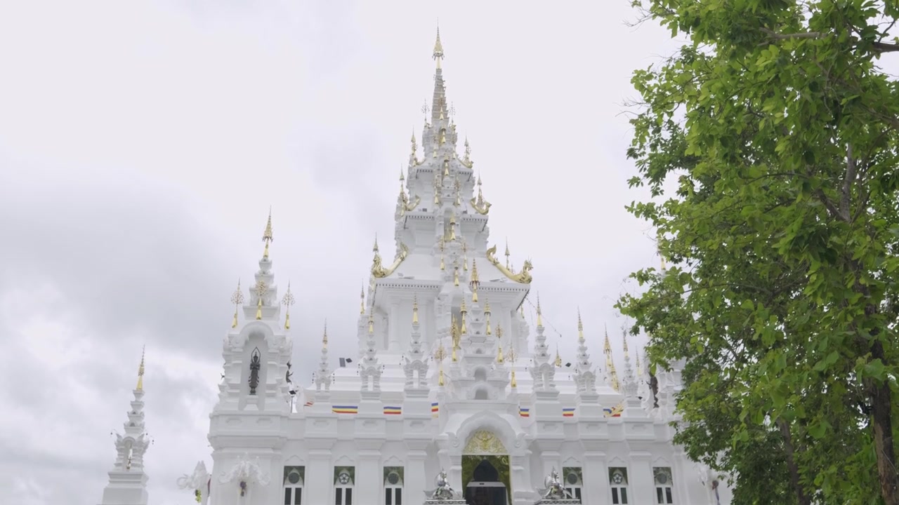 Rivelazione in slow motion con tilt up su un bellissimo tempio bianco contro un cielo nuvoloso.