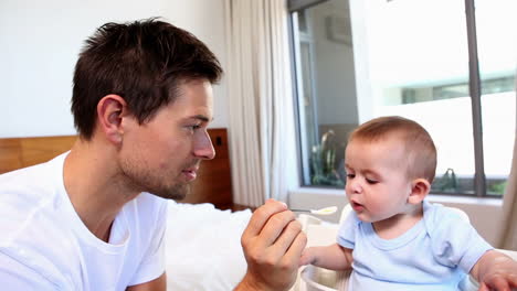 Happy-father-feeding-his-baby-son