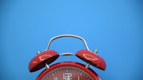 red alarm clock on blue background