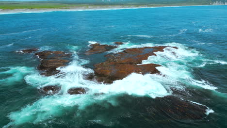 ocean waves crashing on rocky island