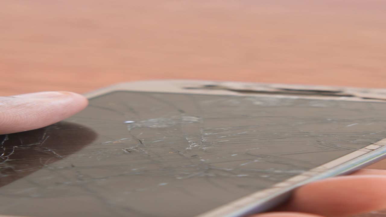 손이 깨진 전화 화면을 만지고 있다