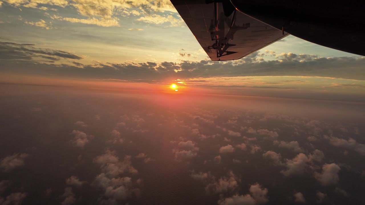 Vista di un bellissimo cielo al tramonto dal finestrino di un passeggero di un aereo d'epoca in volo durante l'ora d'oro, un'esperienza di viaggio aereo cinematografica.