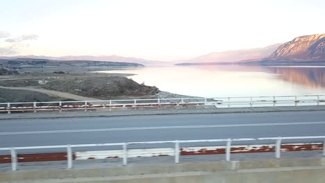 Drone-shot-of-a-girl-riding-a-super-sport-motorcycle-on-a-bridge-over-a-lake-in-Greece