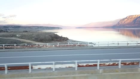 disparo de drones de una niña montando una motocicleta superdeportiva en un puente sobre un lago en grecia