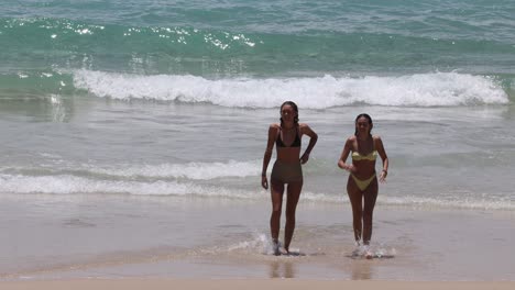 two women walking together on a beach