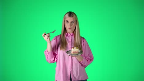 woman eating delicious cake in front of green screen