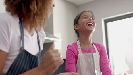 Glückliche-Biracial-Mutter-Und-Tochter-Haben-Spaß-Und-Backen-In-Der-Küche,-Zeitlupe