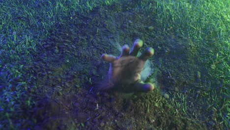 video of hand raising from grass with smoke on black background