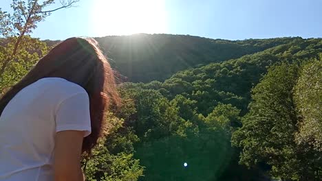 woman enjoying a view of a forest and mountain